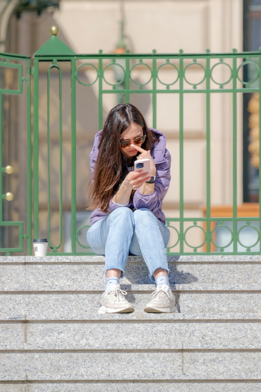 Girl on stairs watching her smartphone